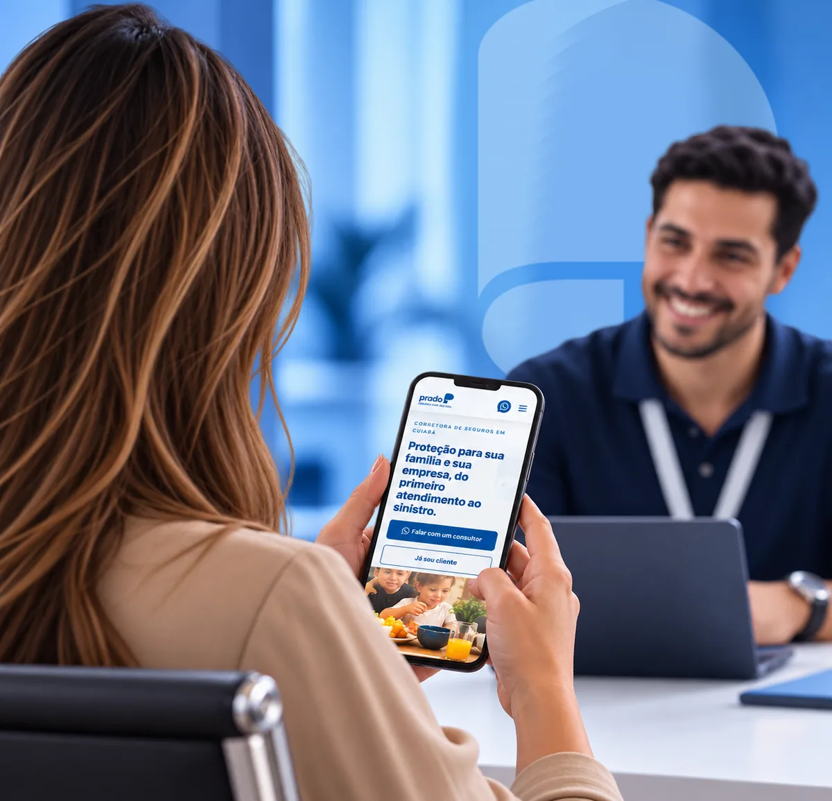Cliente de costas com o site da Prado aberto no celular, atendida por um consultor sorridente